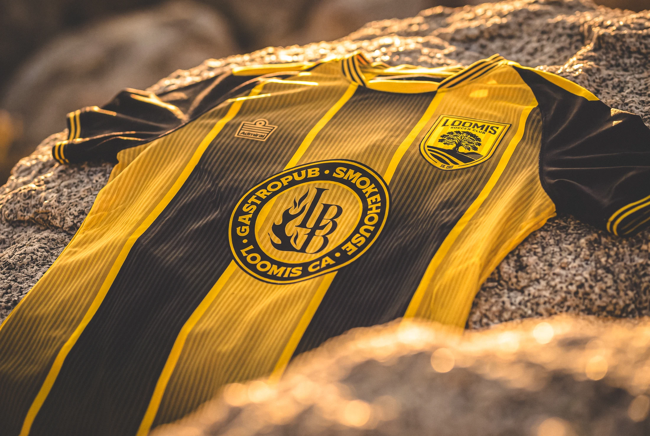 Close detail of the Loomis black-and-gold shirt and crest